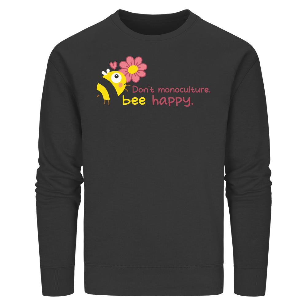Vegan und Bio Unisex Sweatshirt mit Cartoon-Biene, pinker Blume, Herzen und Slogan „Don’t monoculture, bee happy“. Nachhaltige Materialien fördern Artenvielfalt und Naturschutz.