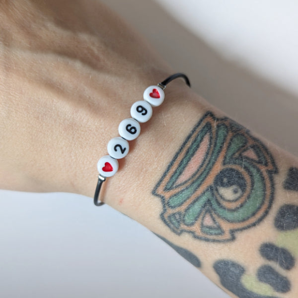 Vegan und handgemacht Armband: 269 mit zwei roten Herzen, bestehend aus wasserfestem Kunstlederband und Kunststoffperlen, gefertigt aus rostfreiem Edelstahl.