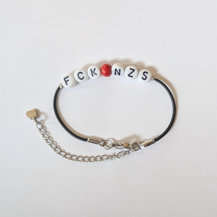 Vegan und handgemacht Armband: FCK NZS mit roter Perle, aus wasserfestem Kunstlederband und Edelstahl, ideal für umweltbewusste und politisch engagierte Träger.