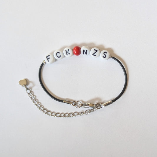 Vegan und handgemacht Armband: FCK NZS mit roter Perle, aus wasserfestem Kunstlederband und Edelstahl, ideal für umweltbewusste und politisch engagierte Träger.