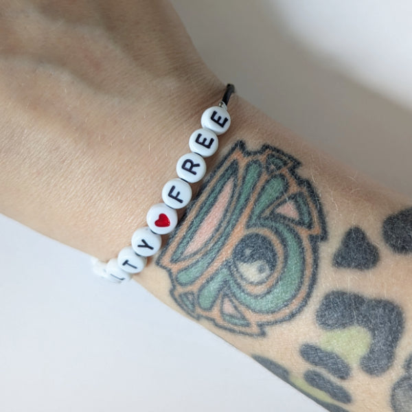 Vegan und handgemacht Armband: Crueltyfree mit rotem Herz, gefertigt aus Natur-Kautschuk und Edelstahl, wasserfest und nachhaltig designt, passend zu RUDE REBELs umweltfreundlichem Sortiment.