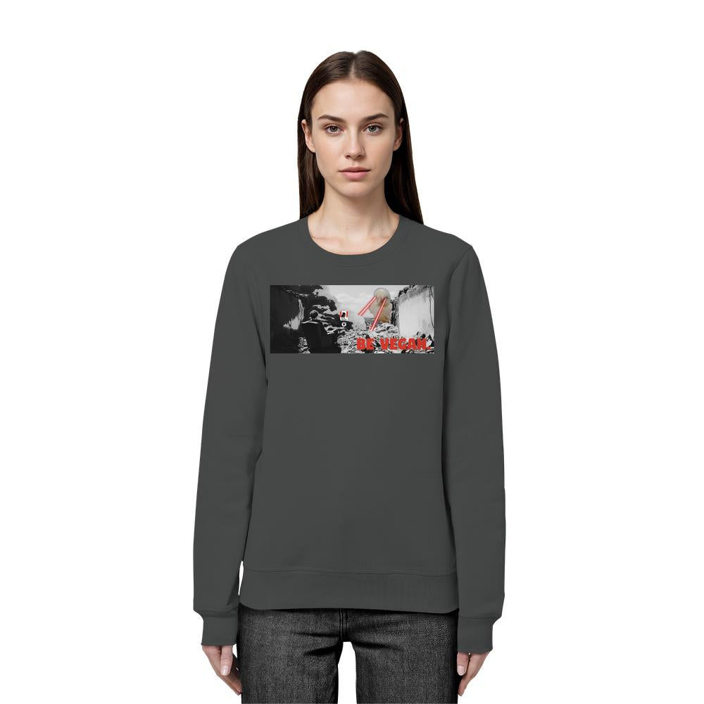 Dunkelgraues Vegan und Bio Sweatshirt: BE VEGAN. - Angry bird, mit rotem Slogan und Collage aus vulkanischem Terrain, getragen von weiblichem Modell.