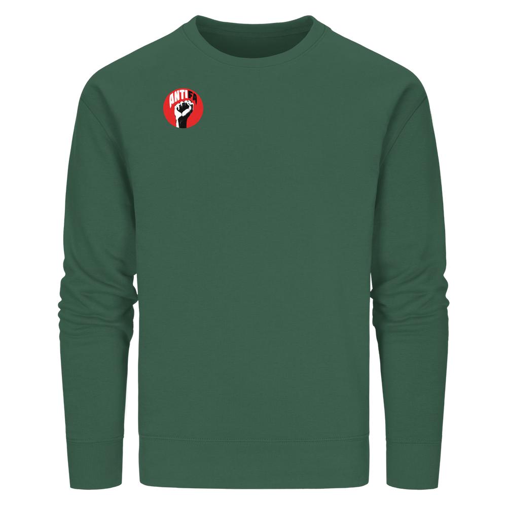 Unisex-Sweatshirt in Waldgrün mit ANTIFA-Logo, aus veganer Bio-Baumwolle, symbolisiert Widerstand gegen Faschismus. Entworfen von RUDE REBEL, fördert Liebe und Demokratie.