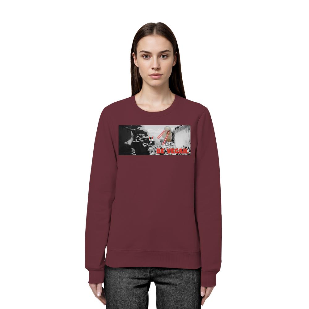 Frau trägt ein maroonfarbenes Vegan und Bio Sweatshirt: BE VEGAN. mit rebellischem Grafikdesign und Slogan, betont nachhaltigen Veganismus. Hergestellt aus Biobaumwolle und recyceltem Polyester.
