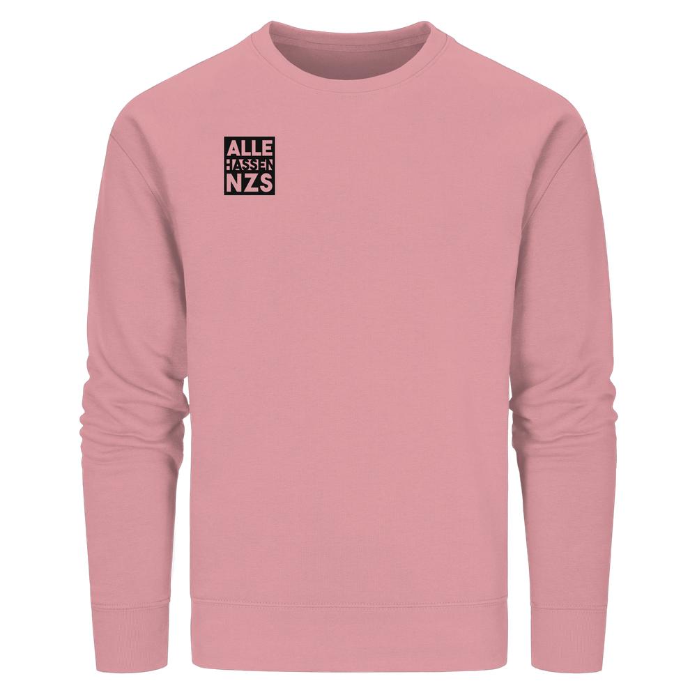Solid-pinkes Unisex-Sweatshirt ALLE HASSEN NZS! mit kleinem, schwarzem Grafikdruck auf der linken Brust. Besteht aus Bio-Baumwolle und recyceltem Polyester.