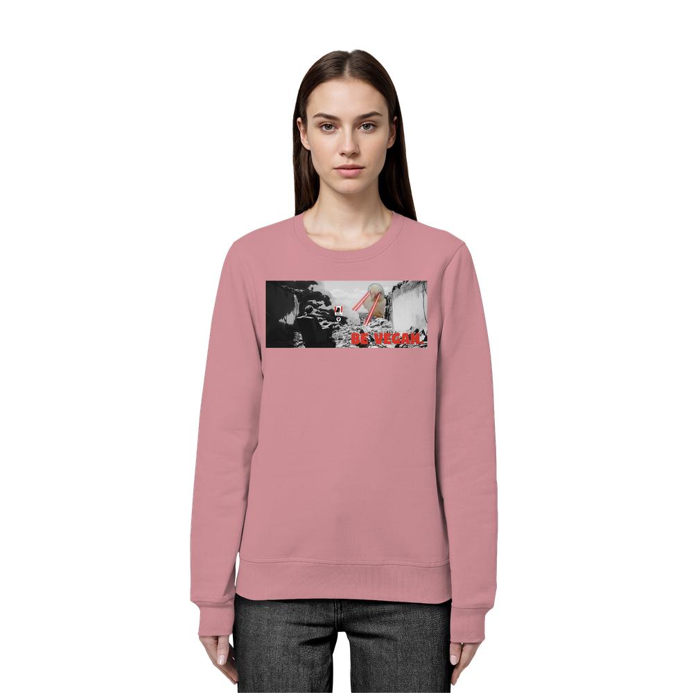 Model trägt Vegan und Bio Sweatshirt: BE VEGAN. - Angry bird mit Grafik eines Schlachthauses, roter Schriftzug “BE VEGAN”, rote Essstäbchen greifen Fleischstück.