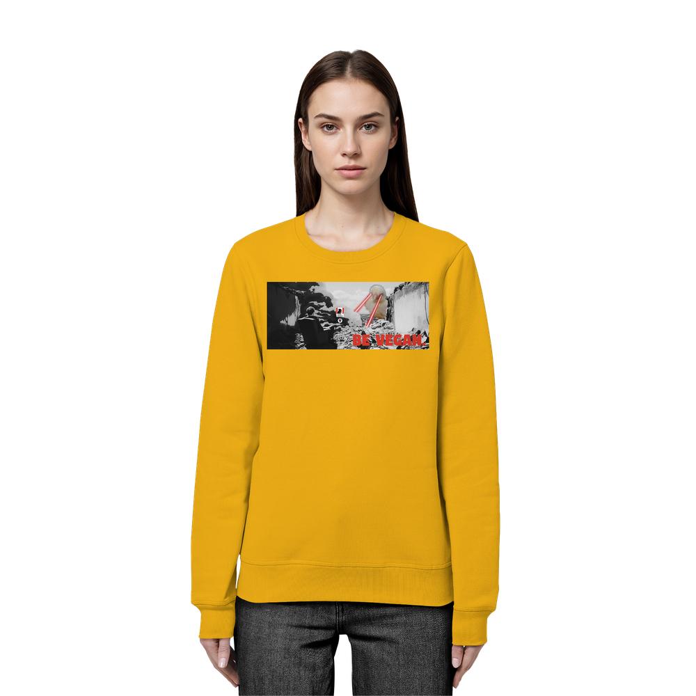 Frau trägt das Vegan und Bio Sweatshirt: BE VEGAN. mit Collage von Berglandschaft, Person, Kanada-Flagge, Strohhalmen und rotem Slogan. Bio-Baumwolle und recyceltes Polyester.