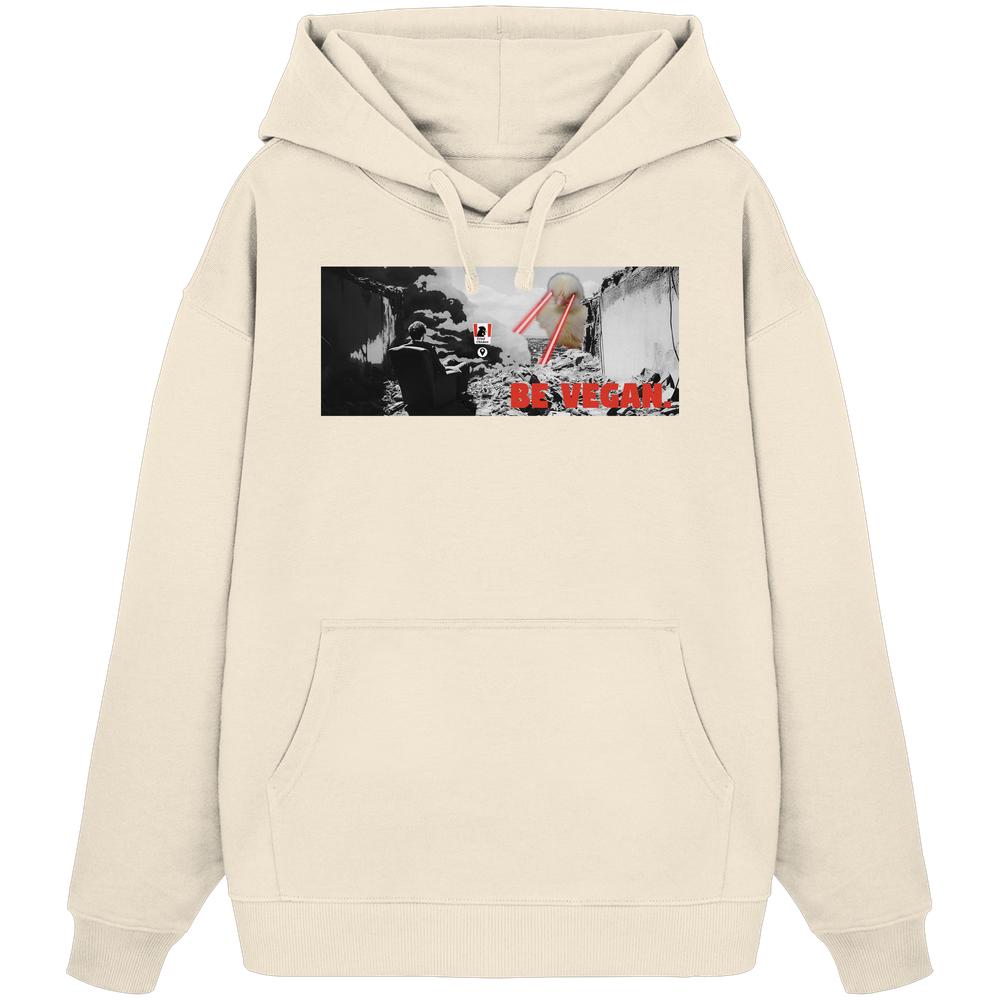 Vegan und Bio Oversized Hoodie: BE VEGAN. - Hellbeiges Hoodie mit dystopischem Grafikdruck, zeigt zerstörte Stadt, Figur, Vogelkopf mit Lasern und BE VEGAN-Slogan.