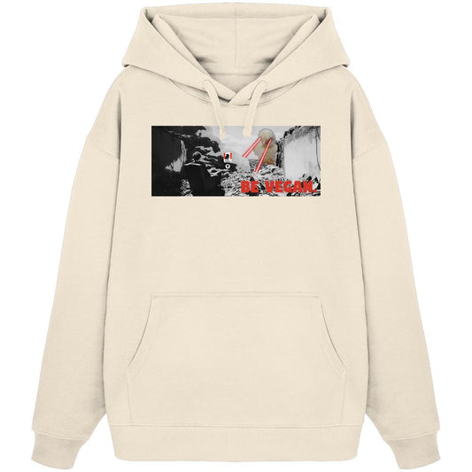 Vegan und Bio Oversized Hoodie: BE VEGAN. - Hellbeiges Hoodie mit dystopischem Grafikdruck, zeigt zerstörte Stadt, Figur, Vogelkopf mit Lasern und BE VEGAN-Slogan.
