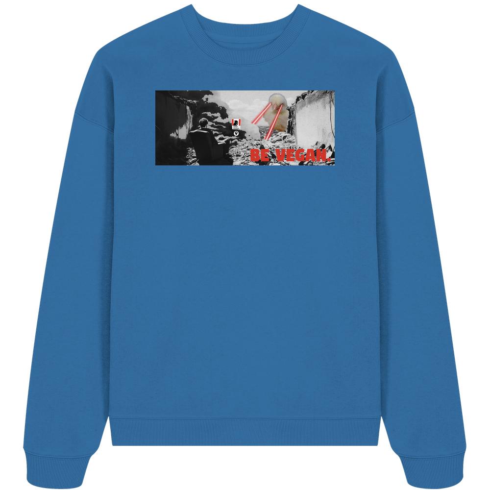 Vegan und Bio Oversized Sweatshirt: BE VEGAN. - Angry bird, blauer Pullover mit apokalyptischem Print und rotem Slogan auf der Brust, aus 100% Bio-Baumwolle.