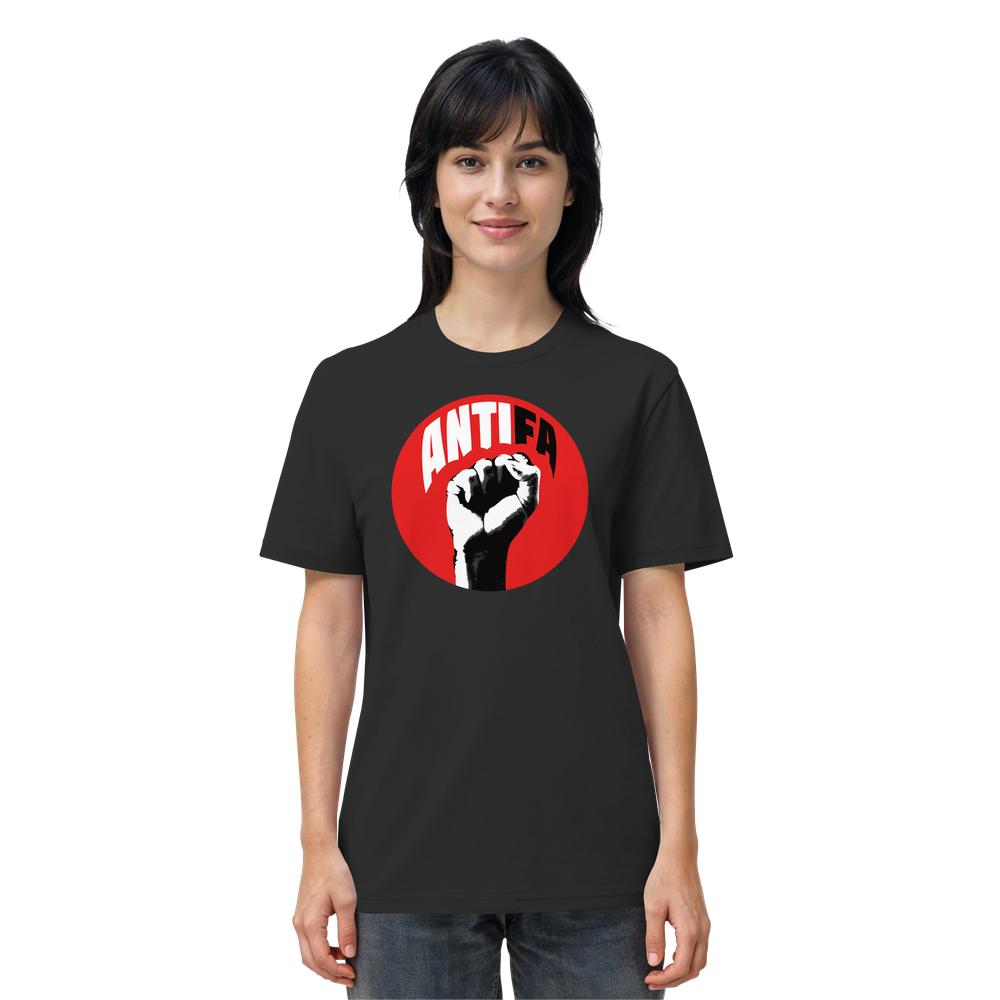 Person trägt das Vegan und Bio Unisex Shirt: Antifa - Kampf gegen Rechts mit einem roten Kreis, weiß-schwarzer Faust und ANTIFA Schriftzug. Material: 100% Bio-Baumwolle.