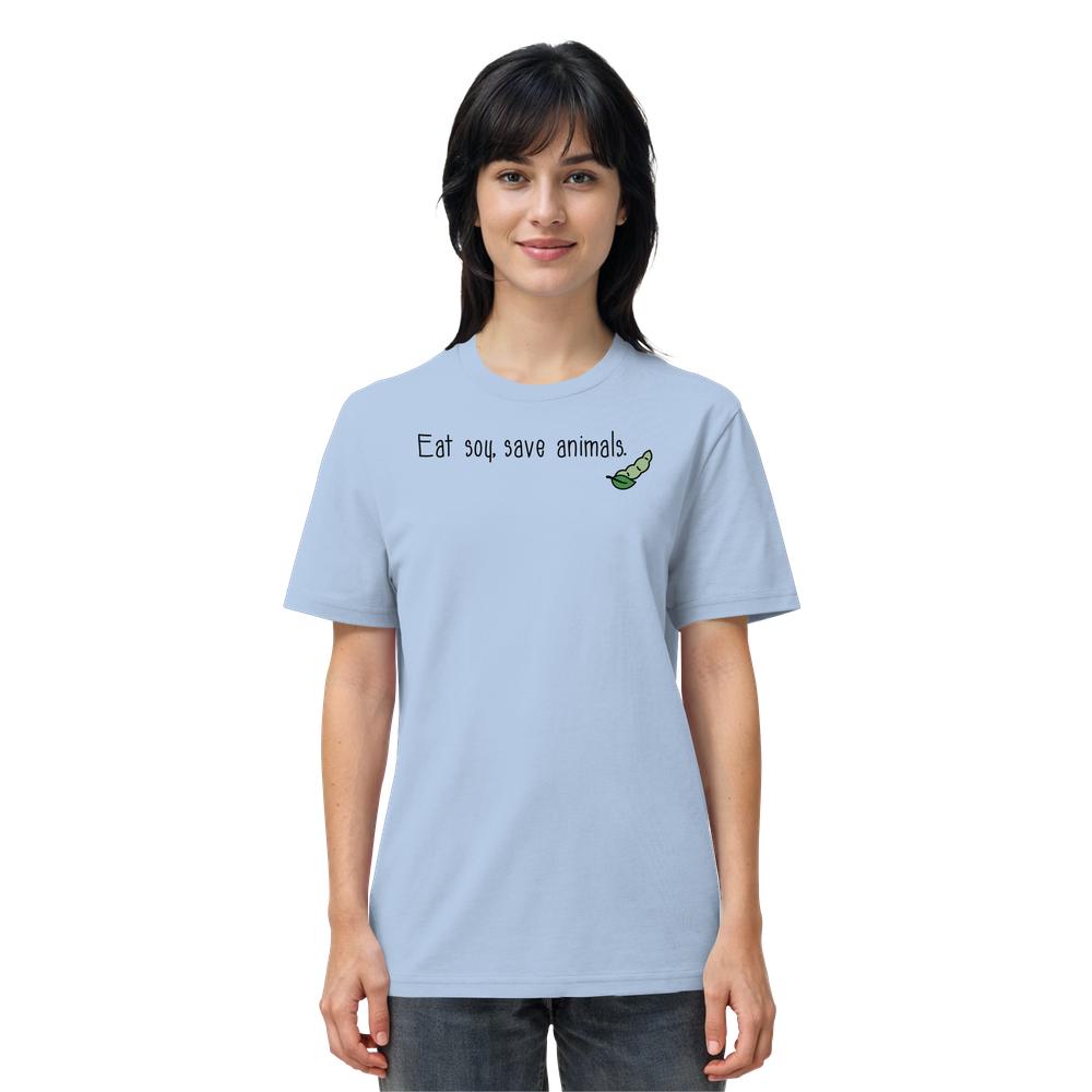Person trägt ein hellblaues T-Shirt mit dem Slogan „Eat soy, save animals“ und einem Cartoon einer grünen Sojabohne. Vegan und Bio Unisex Shirt von RUDE REBEL.