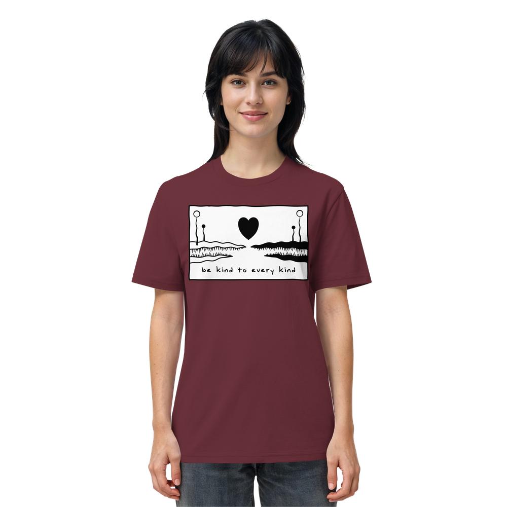 Frau trägt burgunderrotes T-Shirt mit schwarzem Herz und Landschaftsillustration. Text: „be kind to every kind“. Veganes, bio-zertifiziertes Unisex-Shirt von RUDE REBEL.