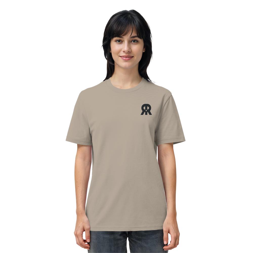 Junge Frau trägt ein beige Vegan und Bio Unisex Shirt bestickt: RUDE REBEL Skull mit schwarzem RR-Logo, verkörpert nachhaltige, rebellische Mode von RUDE REBEL.