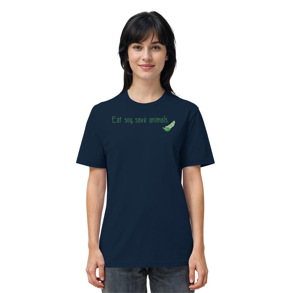 Person trägt ein dunkelblaues T-Shirt mit grünem Slogan Eat soy, save animals und Soja-Illustration. Bio-Baumwolle, normale Passform. Teil von RUDE REBELs veganer Kollektion.