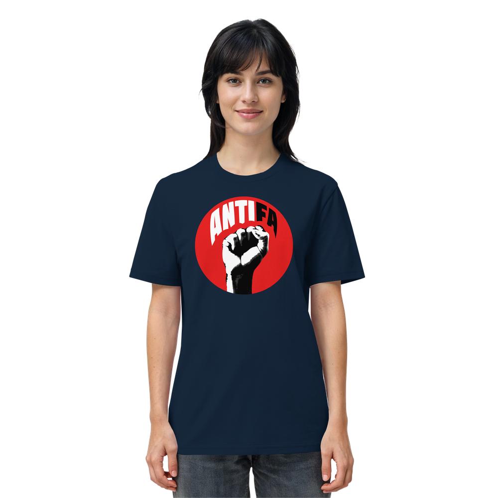 Person trägt dunkelblaues T-Shirt mit ANTIFA-Design: stilisierte Faust auf rotem Hintergrund, Text ANTIFA darüber. Produkt: Vegan und Bio Unisex Shirt: Antifa - Kampf gegen Rechts.