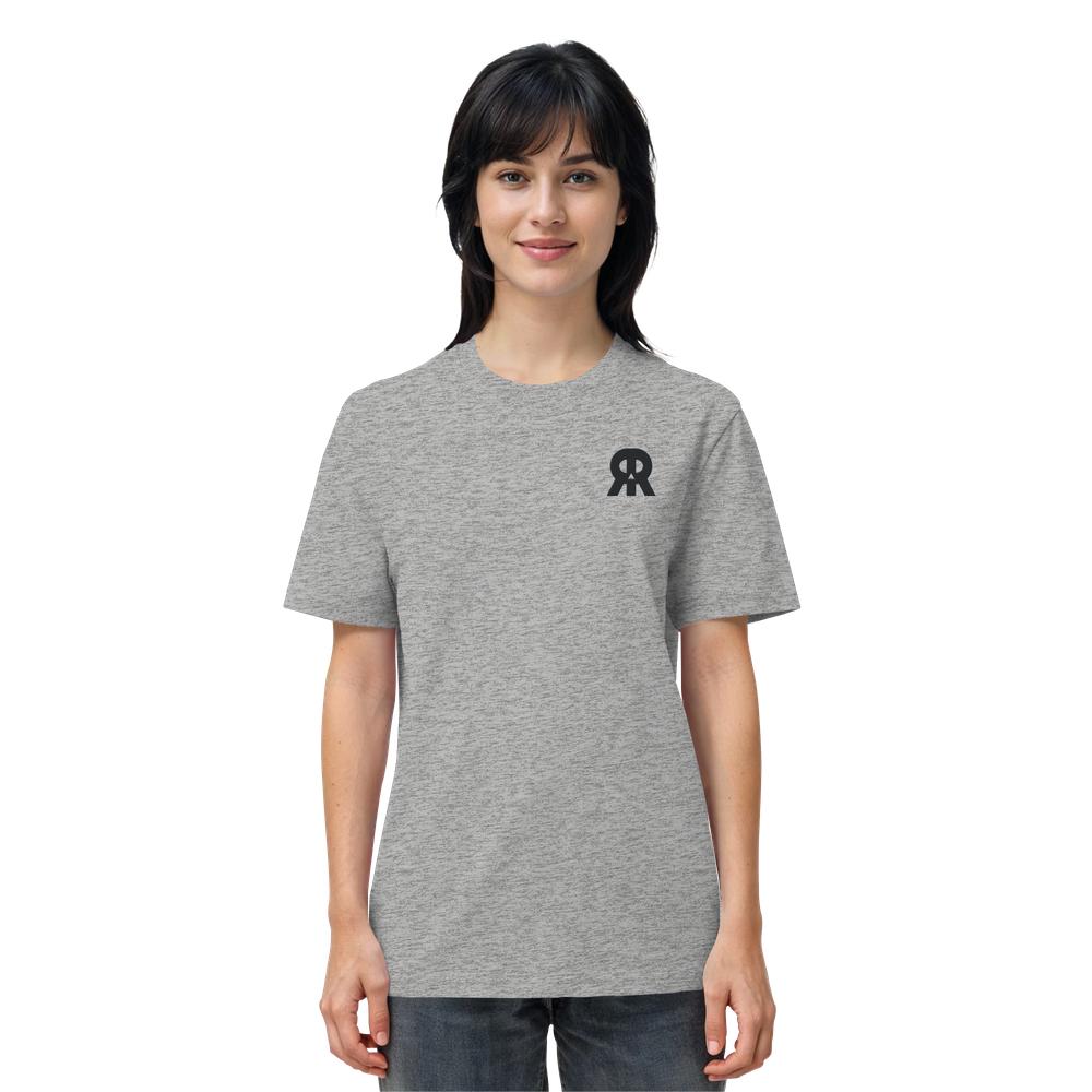 Junge Frau in grauem Vegan und Bio Unisex Shirt bestickt: RUDE REBEL Skull mit schwarzem Logo, symbolisiert rebellisches, nachhaltiges Design von RUDE REBEL.