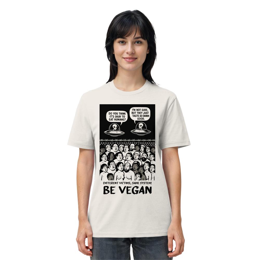 Person trägt das Vegan und Bio Unisex Shirt: Alien Invasion - BE VEGAN! mit Cartoon-Druck von Aliens und Menschenmenge, Aufruf zum Veganismus darunter.