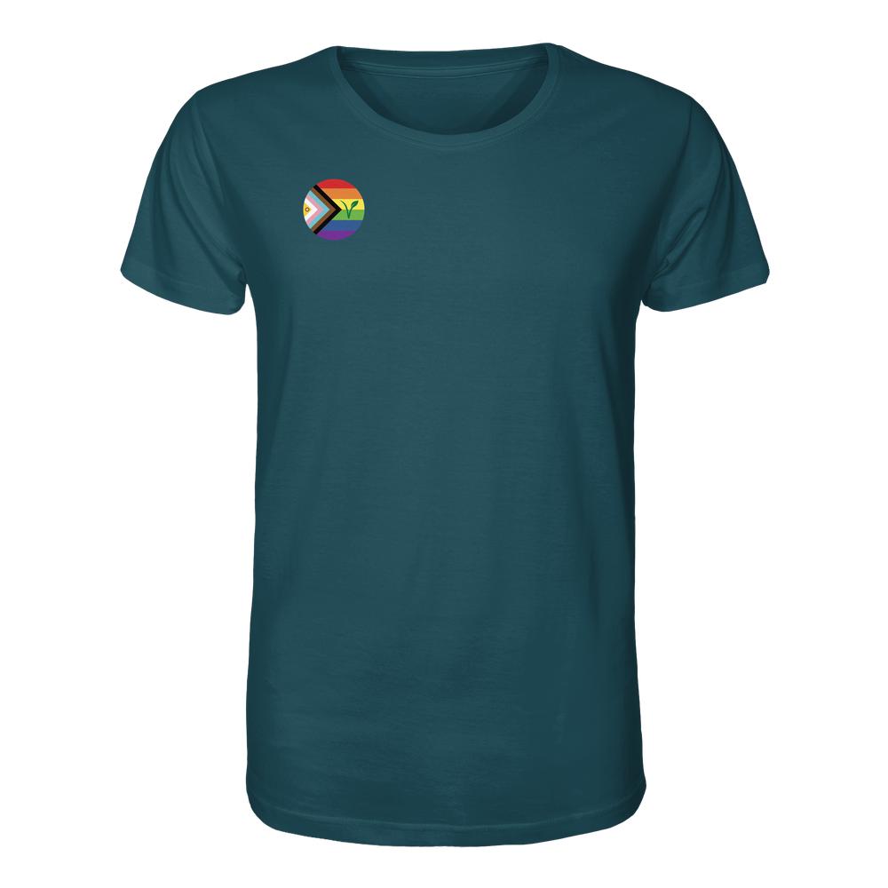 Tealfarbenes Unisex-Shirt mit kleinem, kreisförmigem LGBTQIA+ VEGAN-Logo auf der Brust, aus 100 % Bio-Baumwolle, designed von RUDE REBEL für Freiheit und Nachhaltigkeit.