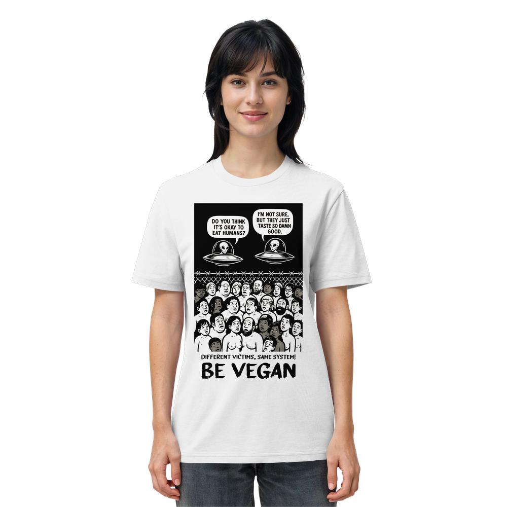Person trägt ein weißes T-Shirt mit Cartoon-Design: Aliens diskutieren über Menschenessen, darunter erschrockene Gesichter hinter Stacheldraht und Text Different victims, same system! BE VEGAN.
