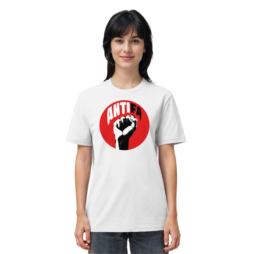 Junge Frau trägt ein weißes Vegan und Bio Unisex Shirt: Antifa - Kampf gegen Rechts mit rotem Kreis, schwarzer Faust und ANTIFA-Schriftzug, stehend vor weißem Hintergrund.