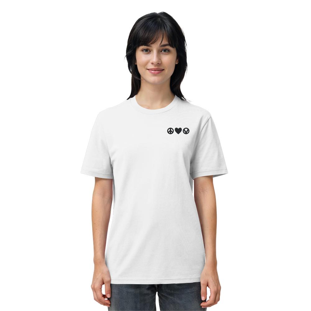 Junge Frau in weißem Bio-Baumwollshirt mit Peace, Love, Veganism-Design von RUDE REBEL, zeigt drei schwarze Symbole: Frieden, Herz, veganer Kreis.