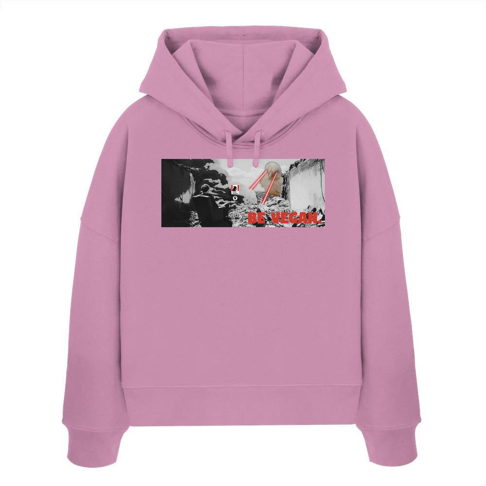 Vegan und Bio Crop Hoodie: BE VEGAN - Pastellrosa Hoodie mit surrealem Druck, zeigt sitzende Figur, riesigen Hühnerkopf mit roten Laseraugen und BE VEGAN-Schriftzug.