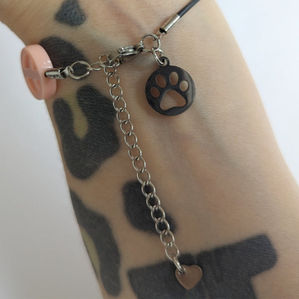 Vegan und handgemacht Halskette: Peace in Altrosa, bestehend aus einem wasserfesten Kunstlederband mit Edelstahl Charm und Kunststoffperle, inspiriert von Tierrechts- und Naturschutzthemen.