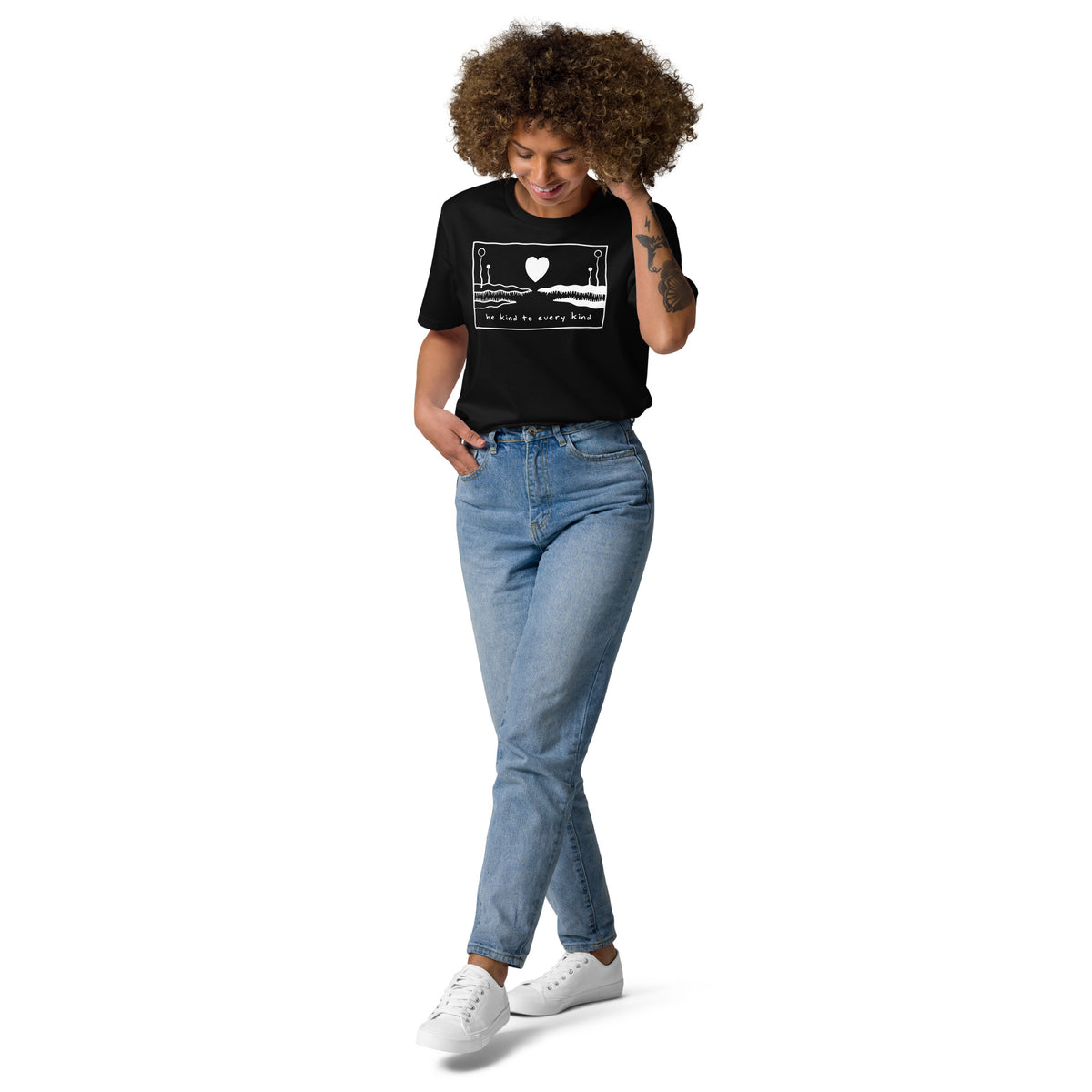 Schwarzes Bio-Baumwoll-T-Shirt mit weißem „Be kind to every kind“-Aufdruck, getragen von einer Frau mit lockigem Haar.